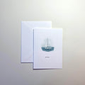 Greeting card with sailboat illustration and envelope on a light gray background