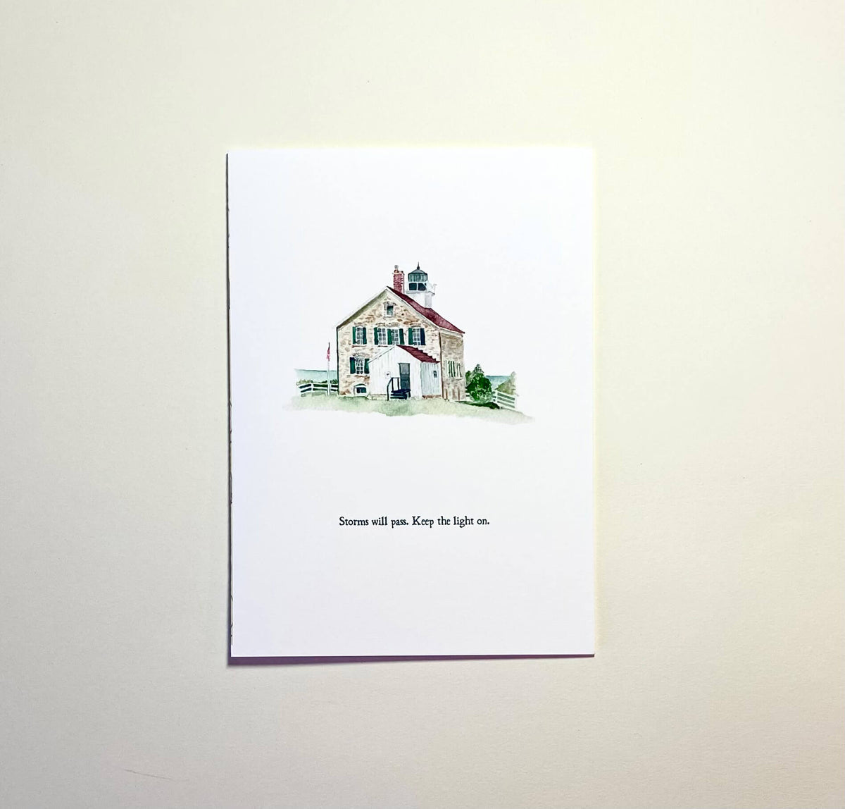 Greeting card with a lighthouse watercolor illustration and text on a white background
