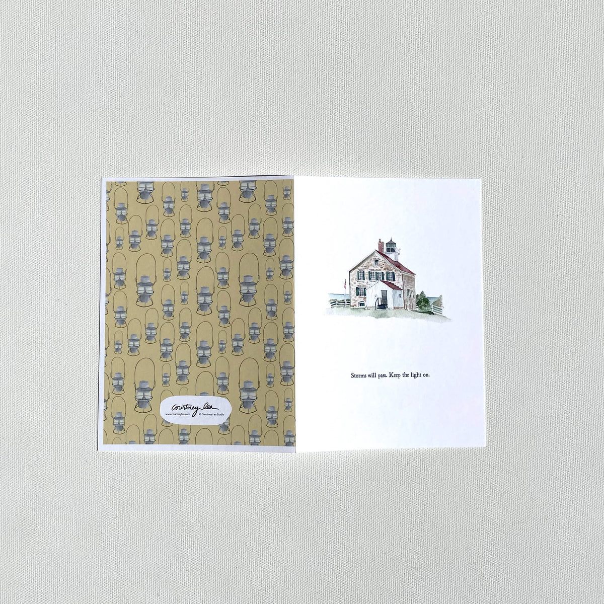 Greeting card showing front (with lighthouse watercolor illustration) and back with lantern pattern
